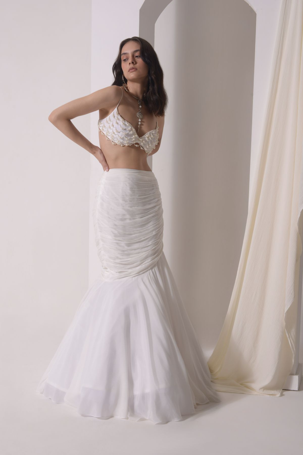 Ruched fish-cut lehenga with beaded bustier and a tulle layered cape