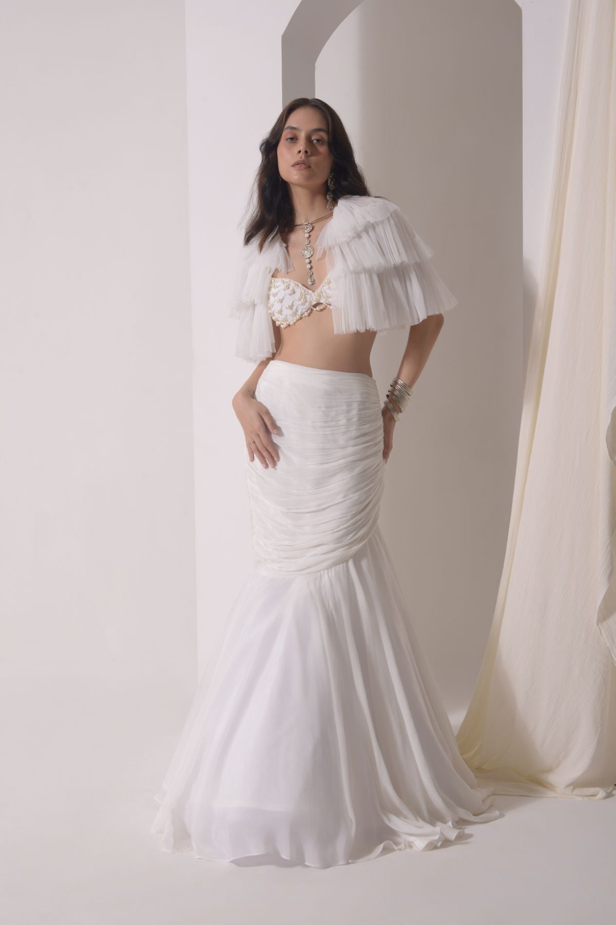 Ruched fish-cut lehenga with beaded bustier and a tulle layered cape